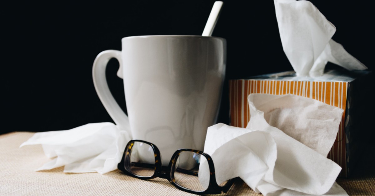 Getting sick with the flu. Using tissues and staying hydrated to combat the virus.